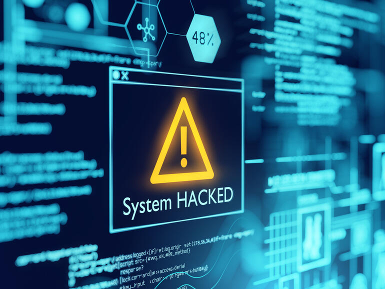 Picture of a computer screen with a box with a caution symbol with system hacked written underneath it, depicting Poly Network crypto hack